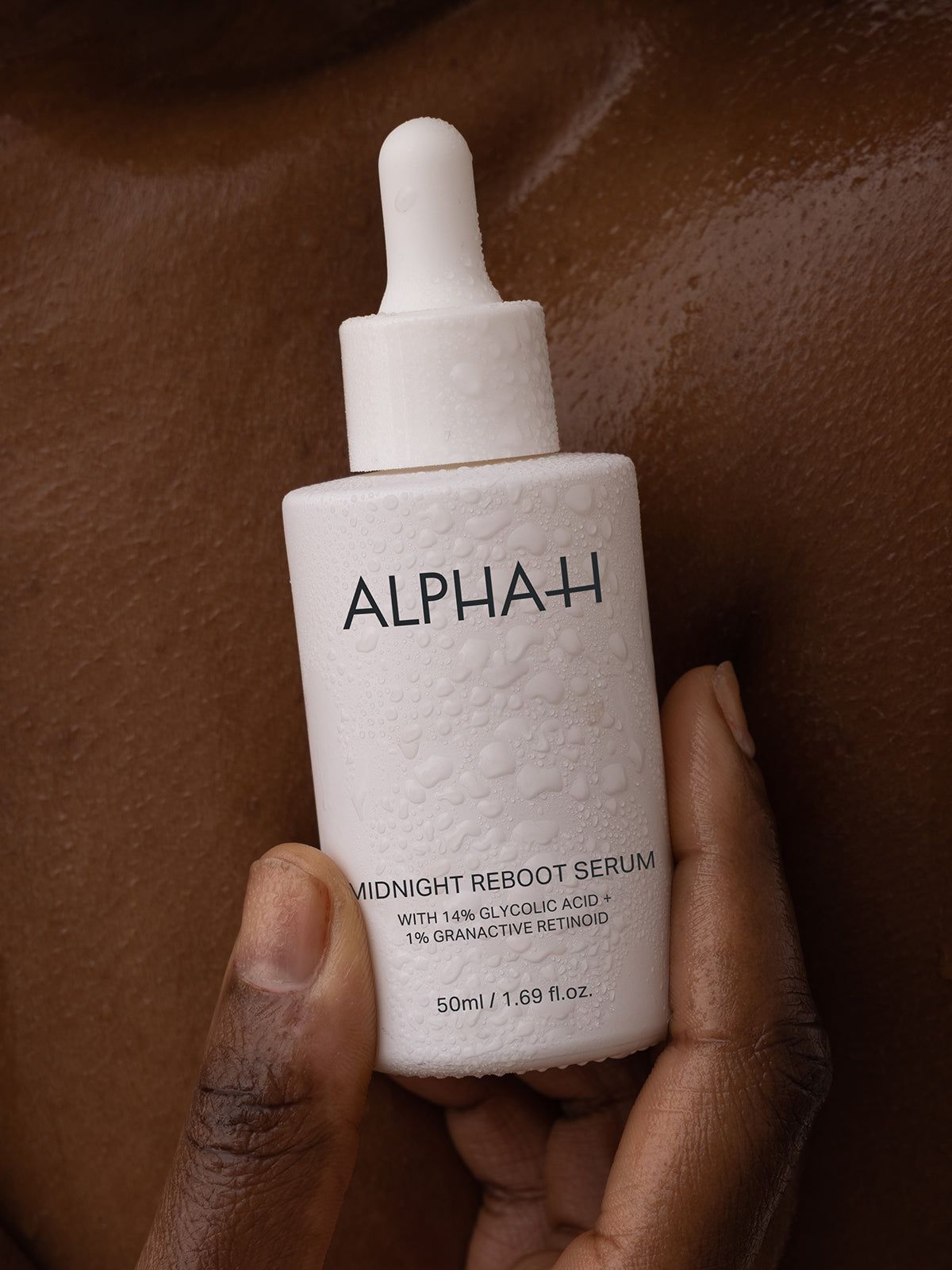 Alpha-H Midnight Reboot Serum held against skin