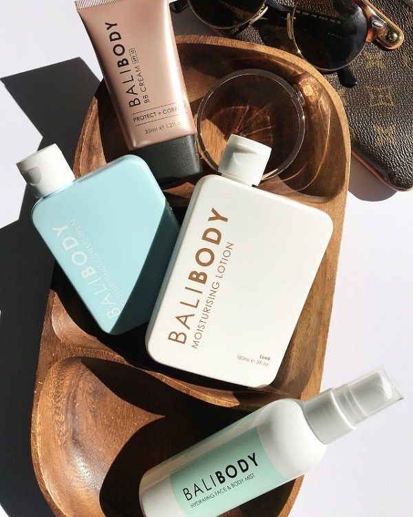 Bali Body campaign — BB Cream + Moisturising Lotion + Hydrating Mist on wood tray with Louis Vuitton bag and sunglasses