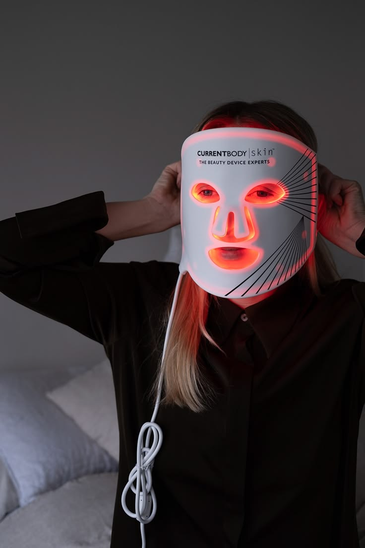 CurrentBody Skin LED Mask held in hand — flexible silicone, full-coverage form