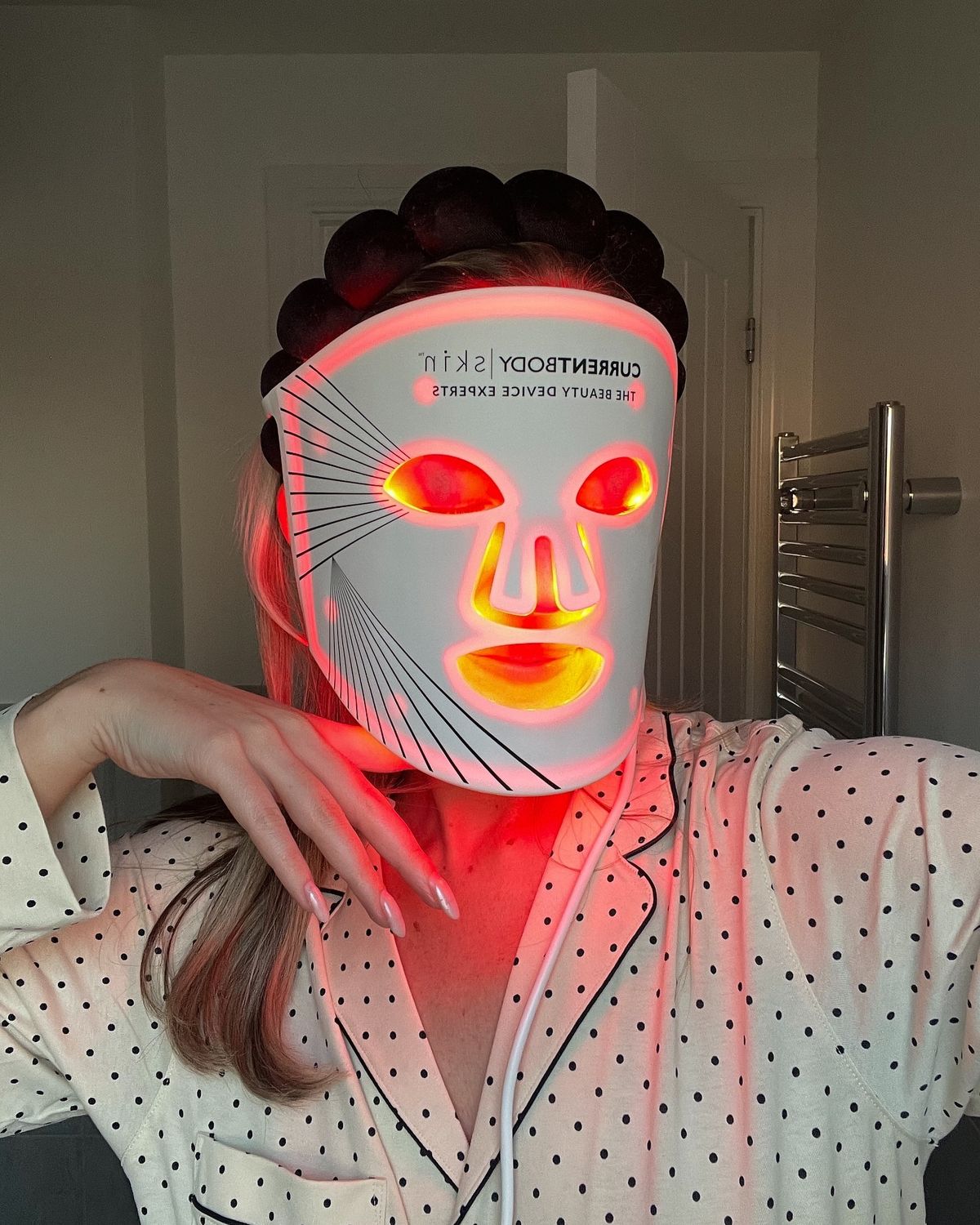 CurrentBody Skin LED Mask flat on a couch — the clinical device at rest in a home