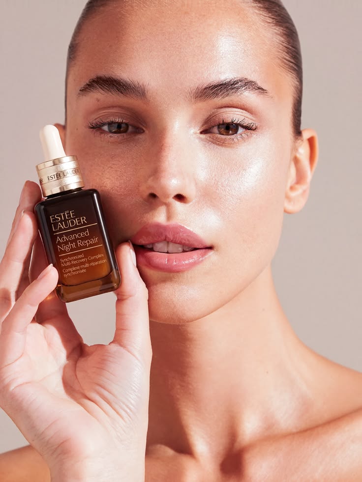 Estée Lauder Advanced Night Repair held to model's face — campaign portrait