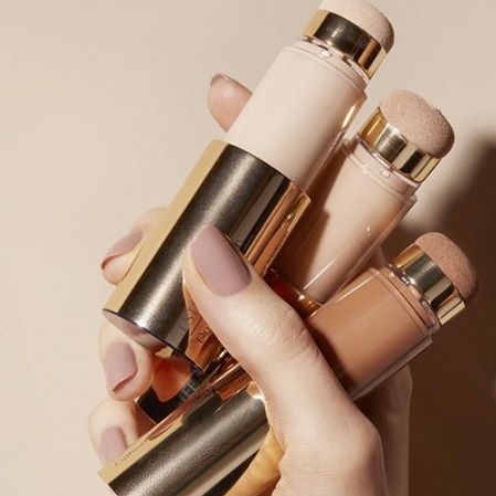 Estée Lauder cushion sticks held in hand