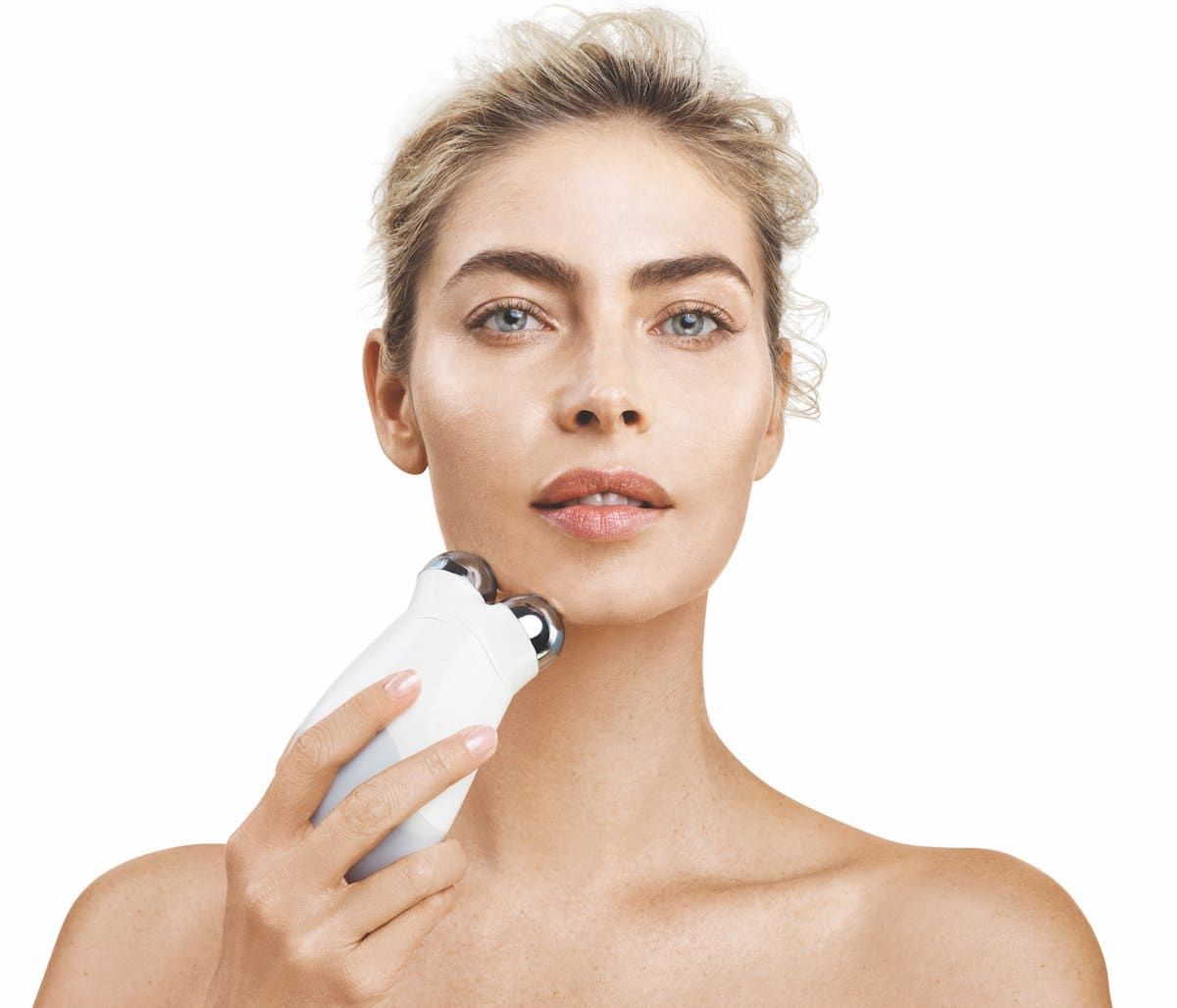 NuFACE Trinity microcurrent device against woman's skin — clean clinical hero