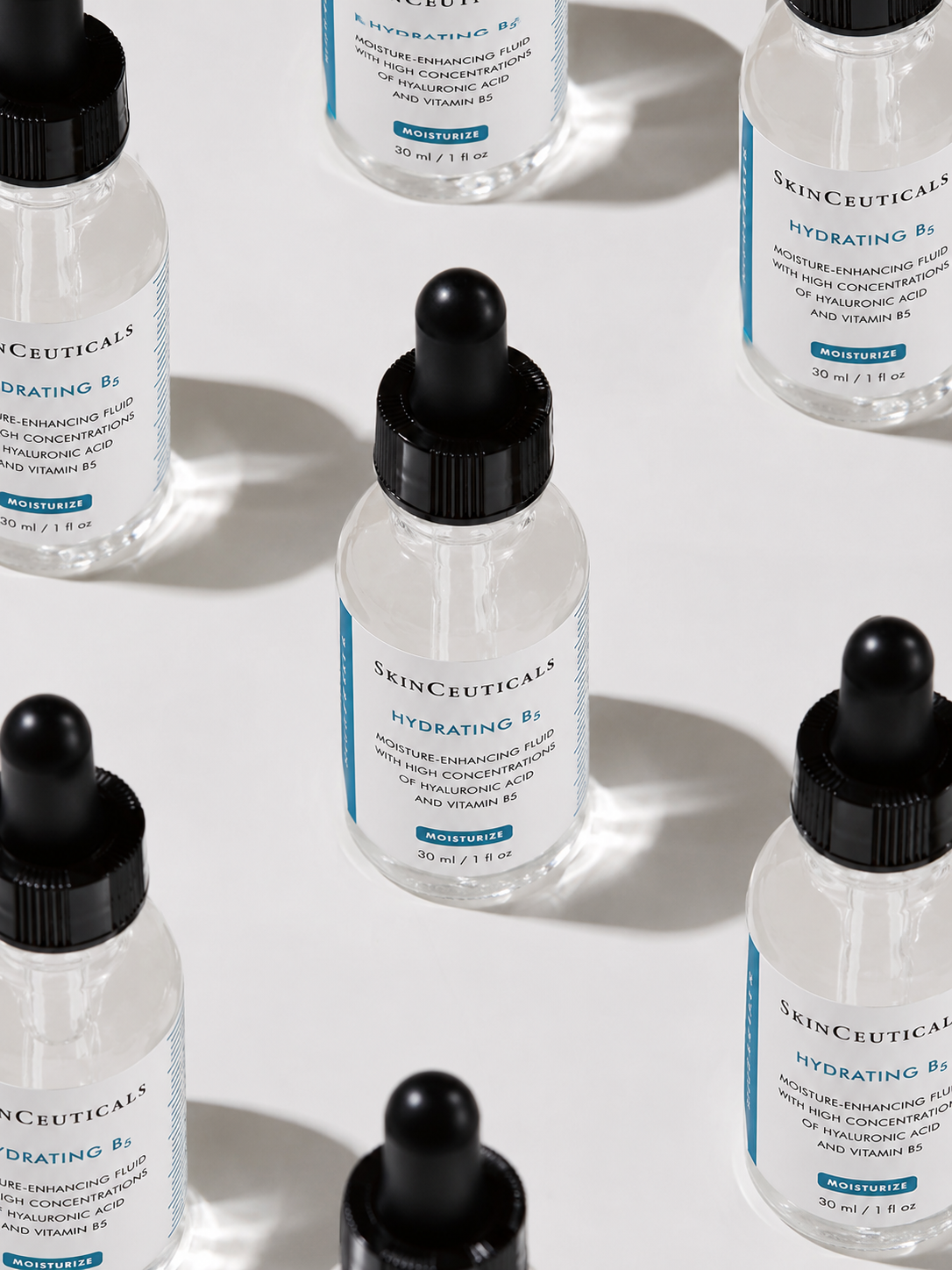 SkinCeuticals Hydrating B5 serum droppers arrayed on white with hard sunlight