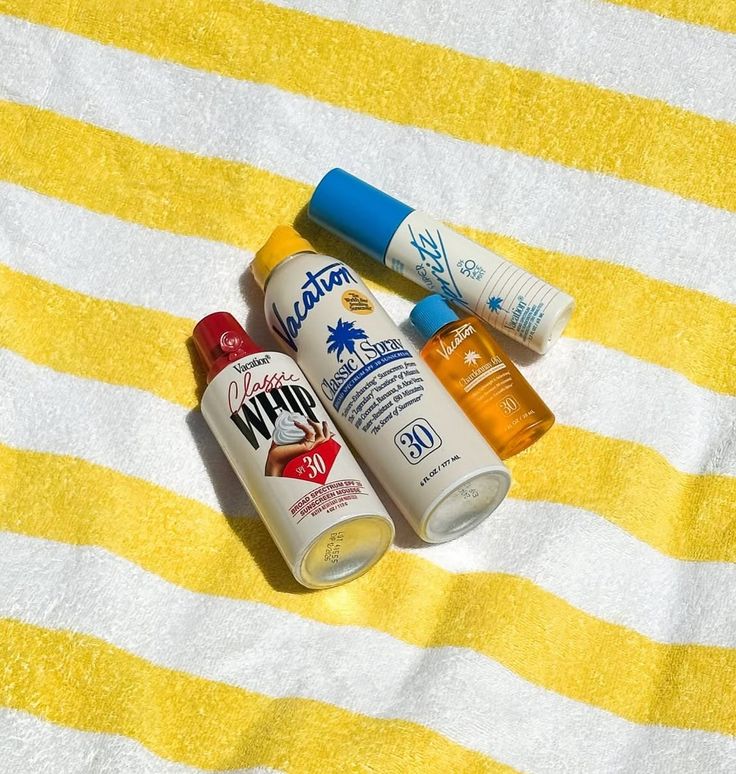 Vacation Classic Whip, Spray and Super Spritz on yellow-striped beach towel