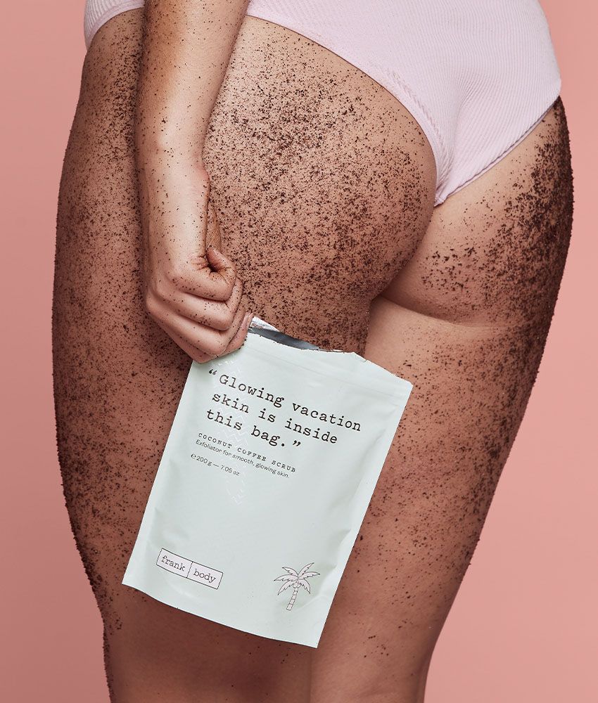 Frank Body Original Coffee Scrub held to a model's thigh — Melbourne body-care editorial