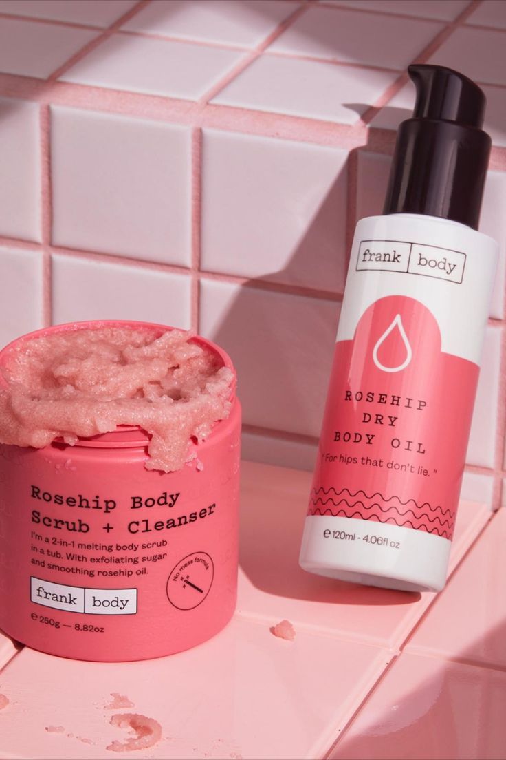 Frank Body Rosehip Body Scrub and Cleanser with Rosehip Dry Body Oil on pink bathroom tile