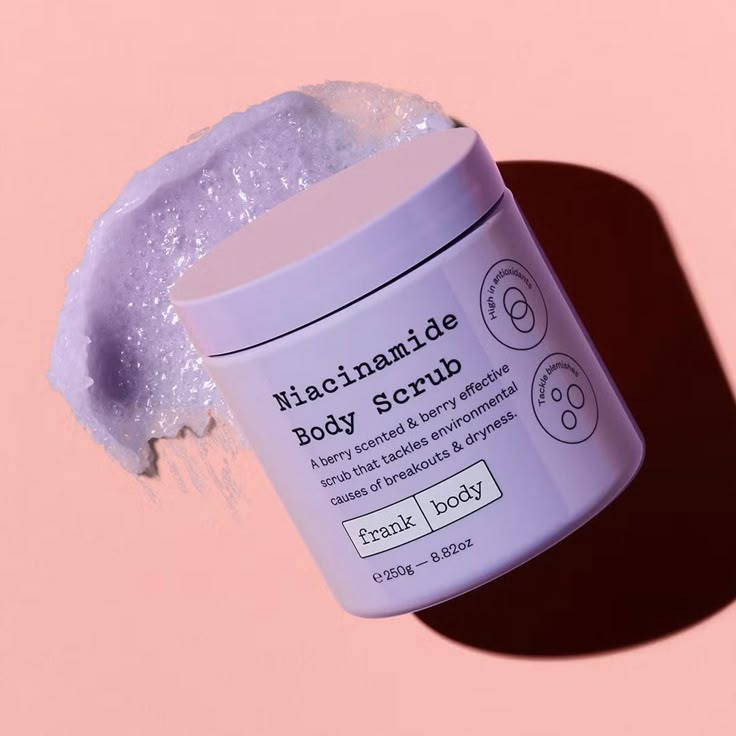 Frank Body Niacinamide Body Scrub on pink studio with foamy product spread