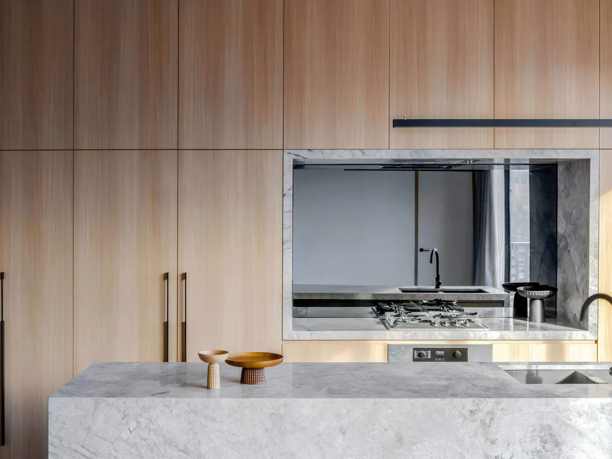 Kitchen front-on: a solid marble island before a wall of oak joinery