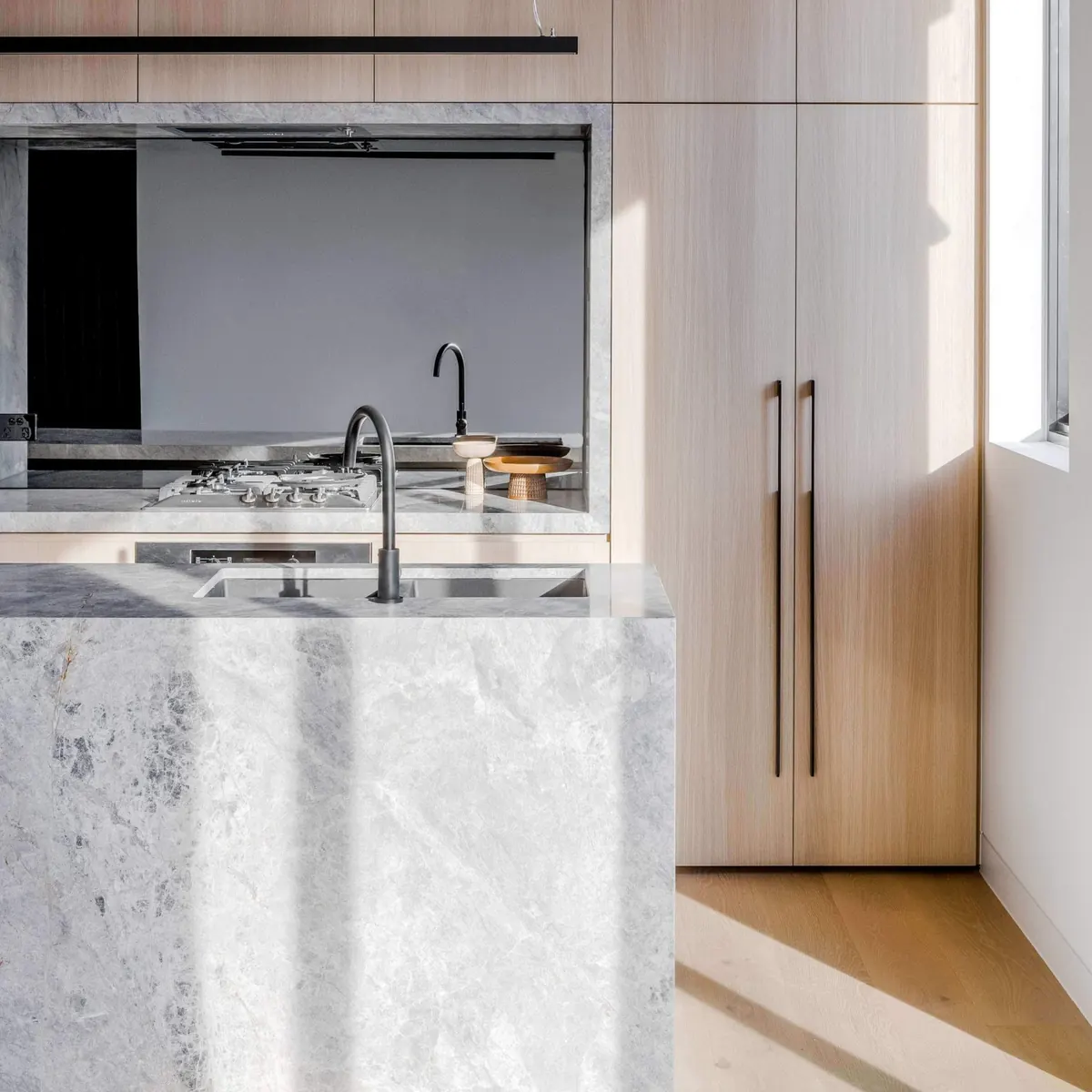 Kitchen detail: marble basin edge, black tapware and oak joinery